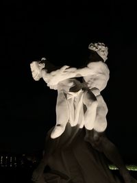 Statue against black background
