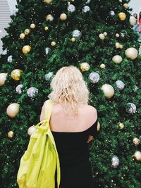 Rear view of woman standing by tree