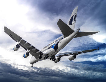 Low angle view of airplane flying against sky