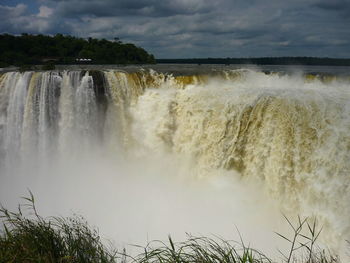 Scenic view of waterfall against sky