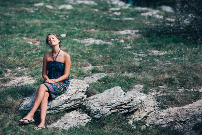 Woman sitting on rock