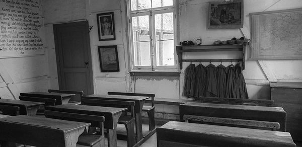 Empty chairs and table in building