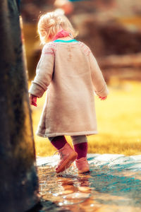 Rear view of girl standing outdoors