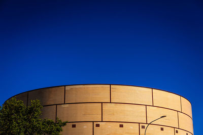 Low angle view of water tower against clear blue sky