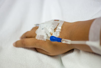 Cropped hand of woman with iv drip in hospital