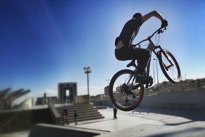 Young boy performing stunts mid-air on his bicycle at park