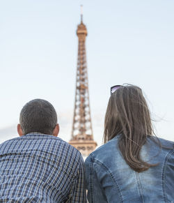 Rear view of man and tower against clear sky