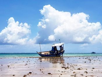 Fishing boat on sea against sky