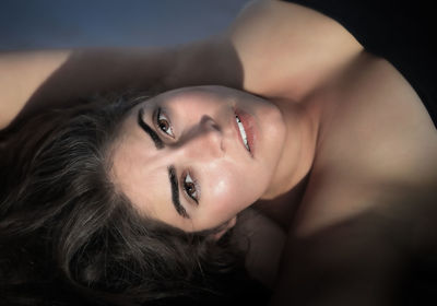 Close-up portrait of young woman lying down