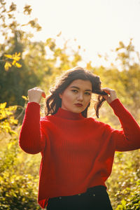 Portrait of young woman holding camera