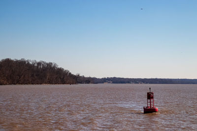 Lighthouse on sea against clear sky