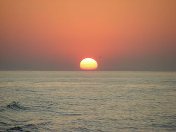 Scenic view of sea against romantic sky at sunset