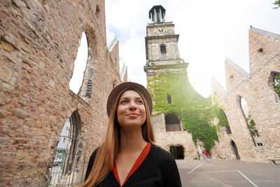 Portrait of tourist girl visiting the ruins of the church of aegidienkirche in hanover, germany