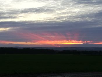 Scenic view of field against sky at sunset