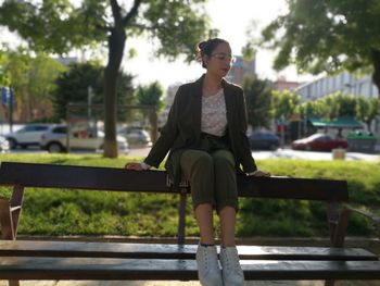 Woman sitting on bench in park