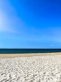 Scenic view of beach against blue sky