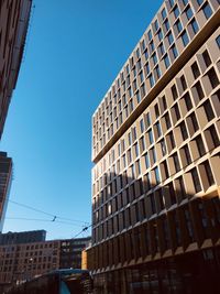 Low angle view of modern building against clear blue sky