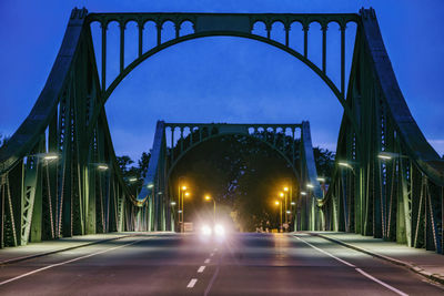 Illuminated bridge against sky at night