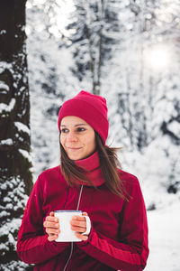 Portrait of young woman standing on snow