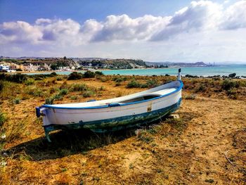 Boat moored on beach against sky