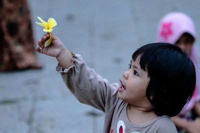 Cute girl holding yellow flower 