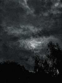 Low angle view of silhouette trees against sky