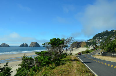 Scenic view of road by sea against sky