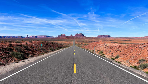 Road amidst field against sky