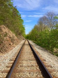 Empty railroad track against cloudy sky