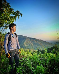 Young man standing on land against sky