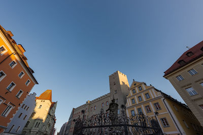 Low angle view of buildings in town against clear sky