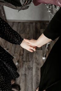 Midsection of couple holding hands