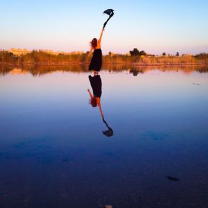 Full length of woman jumping in lake