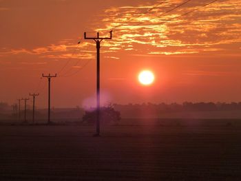 Scenic view of silhouette field against sky during sunset