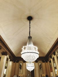 Low angle view of illuminated chandelier hanging on ceiling