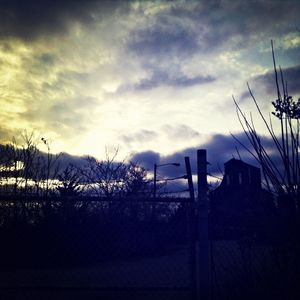 Low angle view of power lines against cloudy sky