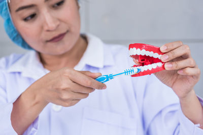 Doctor brushing dentures at clinic