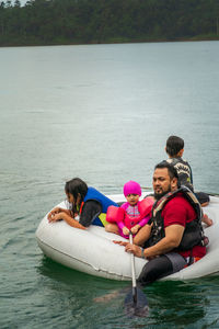 People sitting on boat in lake