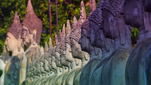 Close-up of buddha statues in row