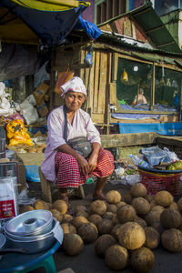 Portrait of woman holding fruits at market
