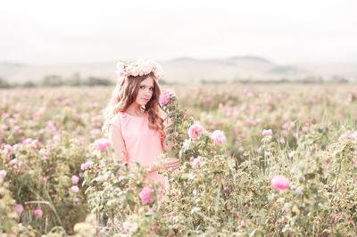 Portrait of teenager girl wearing wreath standing in agricultural field
