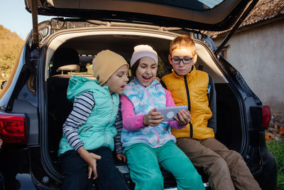 Portrait of smiling friends sitting in car