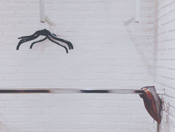 Shoes hanging on rack amidst wall at home