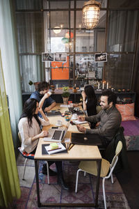 High angle view of creative business team working at table in modern office