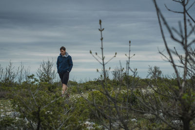 Man walking on land against sky