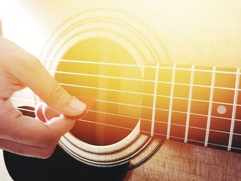 Midsection of man playing guitar