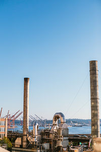 View of factory against clear blue sky