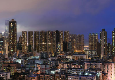 Illuminated buildings in city against sky at night