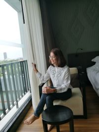 Portrait of young woman sitting on chair