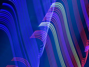 Multi colored light trails on blue background